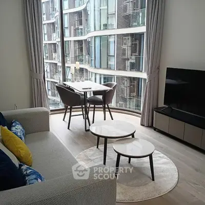 Modern living room with floor-to-ceiling windows and stylish furniture in urban apartment.