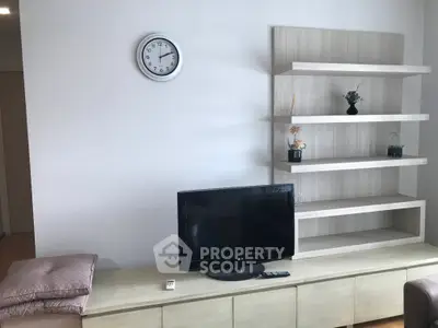 Modern living room with sleek TV setup and stylish shelving unit.