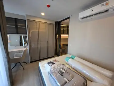 Modern bedroom with sleek design, featuring a built-in wardrobe and air conditioning unit, perfect for comfort.