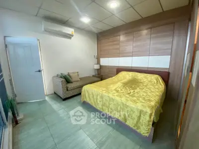 Cozy bedroom with modern decor and comfortable seating area, perfect for relaxation.