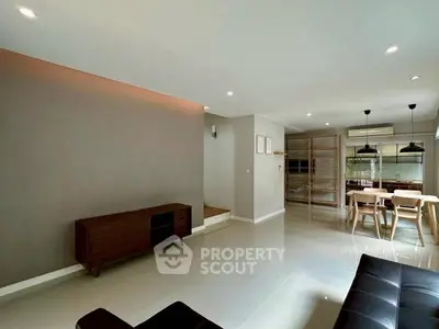 Spacious modern living and dining area with sleek furniture and natural light.