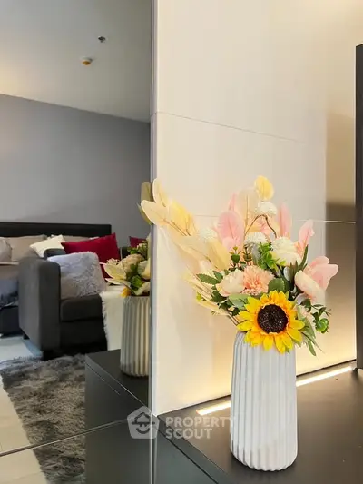 Stylish bedroom with elegant decor and cozy ambiance, featuring a plush bed and decorative floral arrangement.