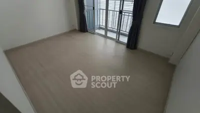 Spacious empty room with large windows and wooden flooring, perfect for customization.