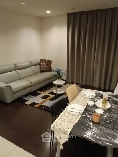 Modern living room with cozy seating and elegant dining area in a stylish apartment.
