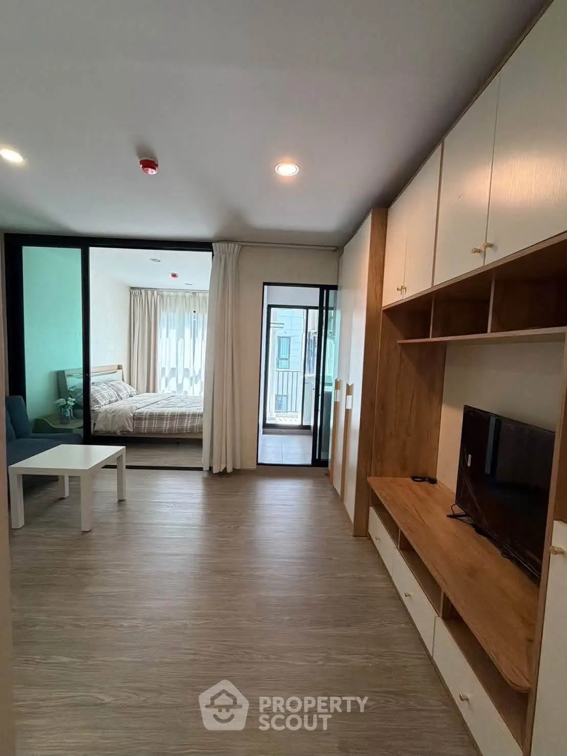 Modern apartment interior with open living area and bedroom view