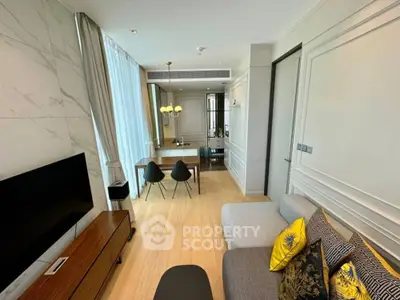 Modern living room with stylish decor and dining area, featuring a sleek TV setup and elegant lighting.