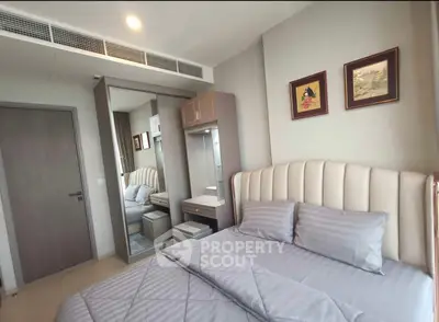 Modern bedroom with stylish decor and mirrored wardrobe in a cozy apartment.