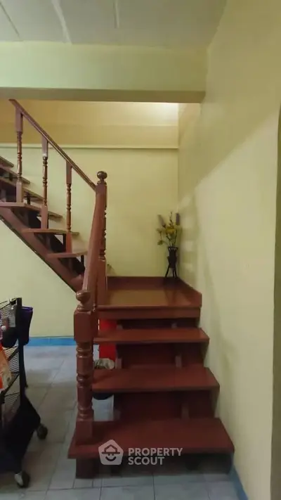 Charming wooden staircase in cozy home interior with warm lighting.