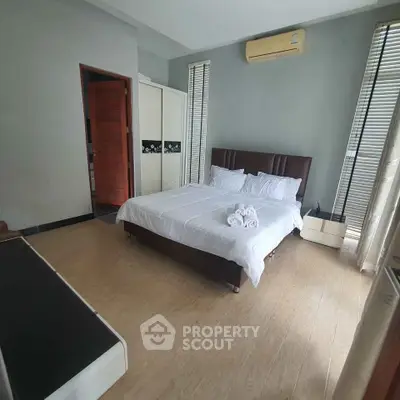 Spacious bedroom with modern decor and natural light, featuring a comfortable bed and stylish furnishings.