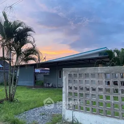 Charming single-story home with carport and lush greenery at sunset.