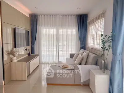 Elegant living room with modern decor, large windows, and cozy seating area.