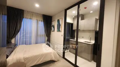 Modern bedroom with glass partition and sleek kitchen design