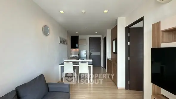 Modern open-plan living room with dining area and sleek kitchen in a stylish apartment.