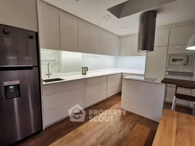 Modern kitchen with sleek white cabinets and stainless steel appliances