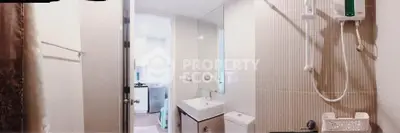 Modern bathroom with sleek fixtures and a view into the adjacent kitchen area.