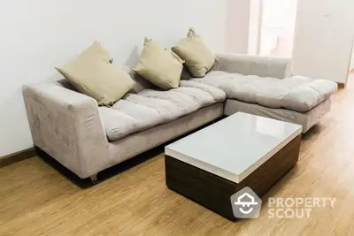 Spacious and modern living room with a large comfortable sectional sofa and a stylish wooden coffee table on sleek hardwood flooring.