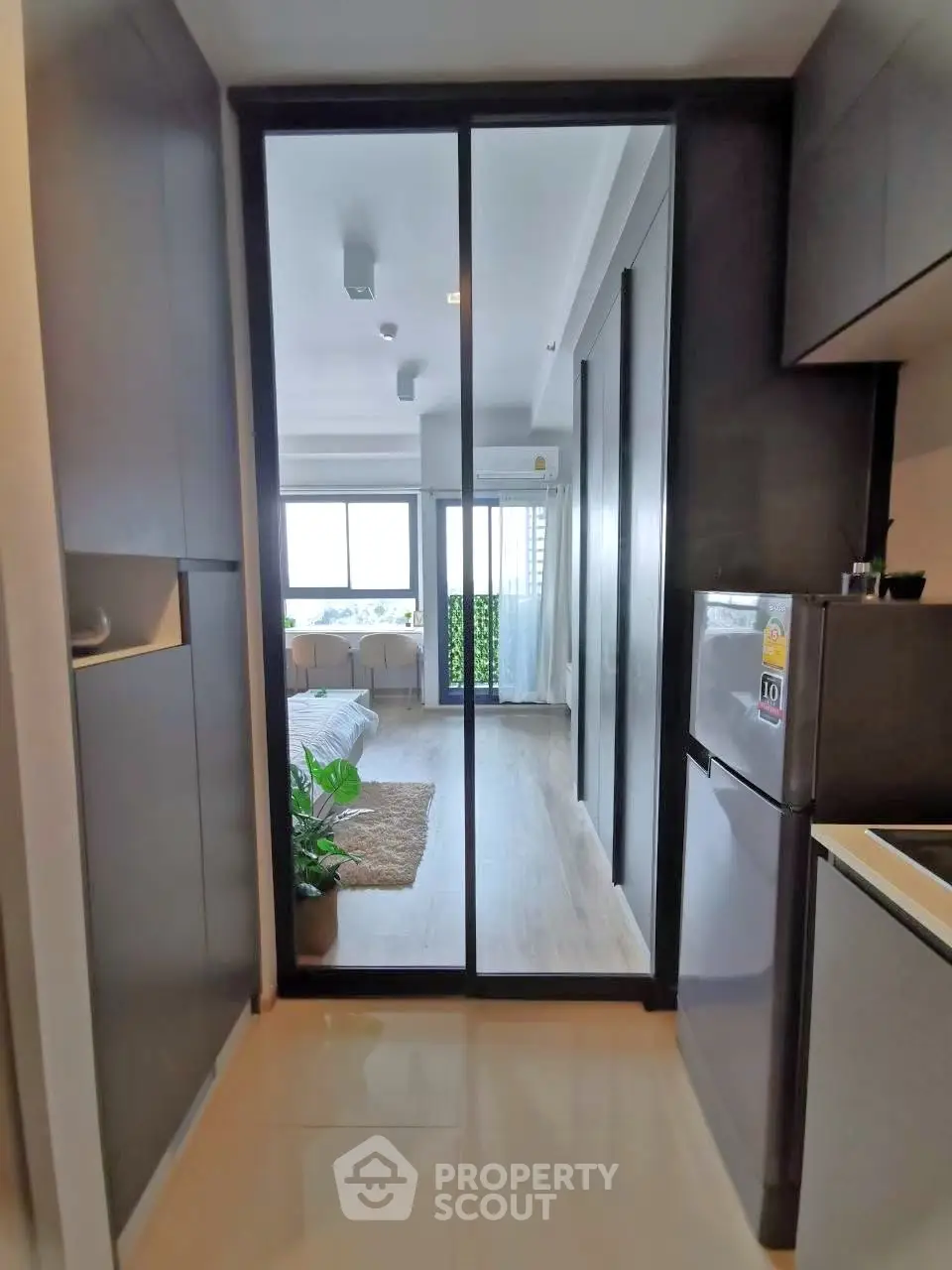 Modern apartment interior with sleek kitchen and spacious living area view.