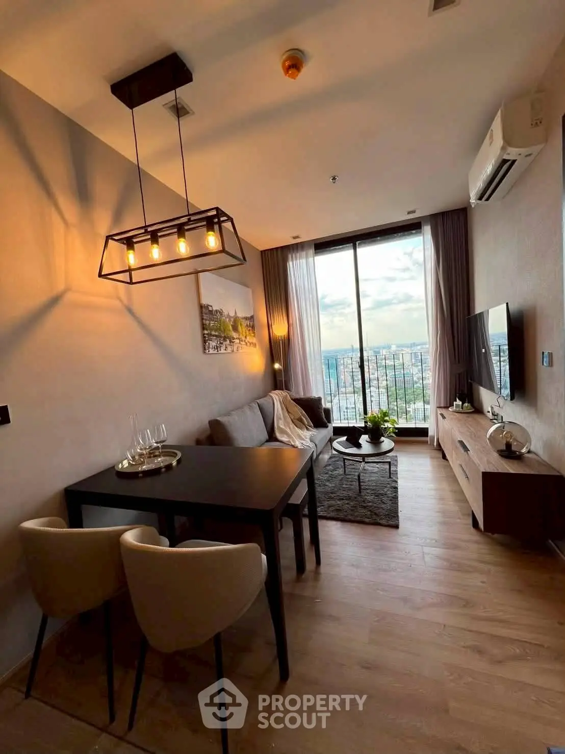 Stylish modern living room with large window and city view, featuring elegant lighting and cozy seating area.
