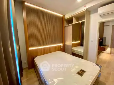 Modern bedroom with stylish wooden paneling and built-in wardrobe in a cozy apartment.