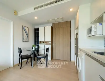 Modern kitchen with dining area, featuring sleek appliances and stylish decor in a contemporary apartment.