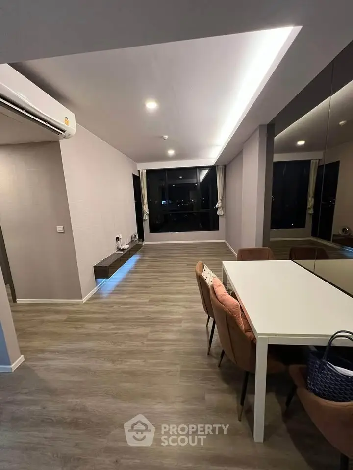 Modern living room with sleek design and large windows offering city views.