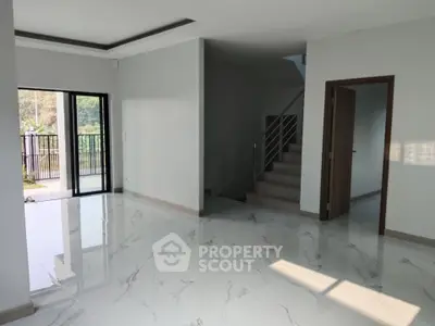 Spacious modern living room with marble flooring and balcony access in a contemporary home.