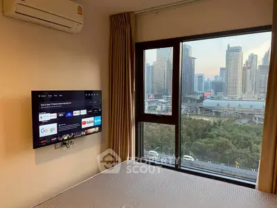 Modern bedroom with city view and wall-mounted TV in high-rise apartment