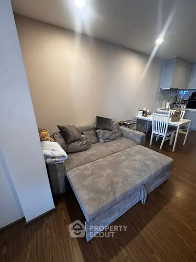 Cozy living room with modern sofa and dining area in open layout apartment.