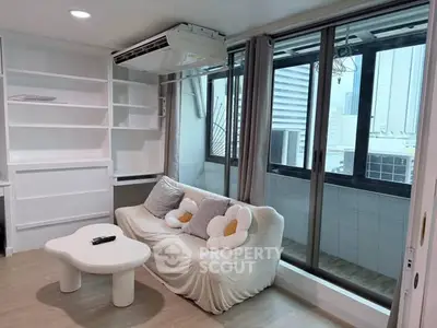 Modern living room with cozy sofa and large windows offering city views, perfect for urban living.