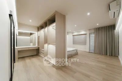 Spacious modern bedroom with elegant wooden flooring and built-in closet