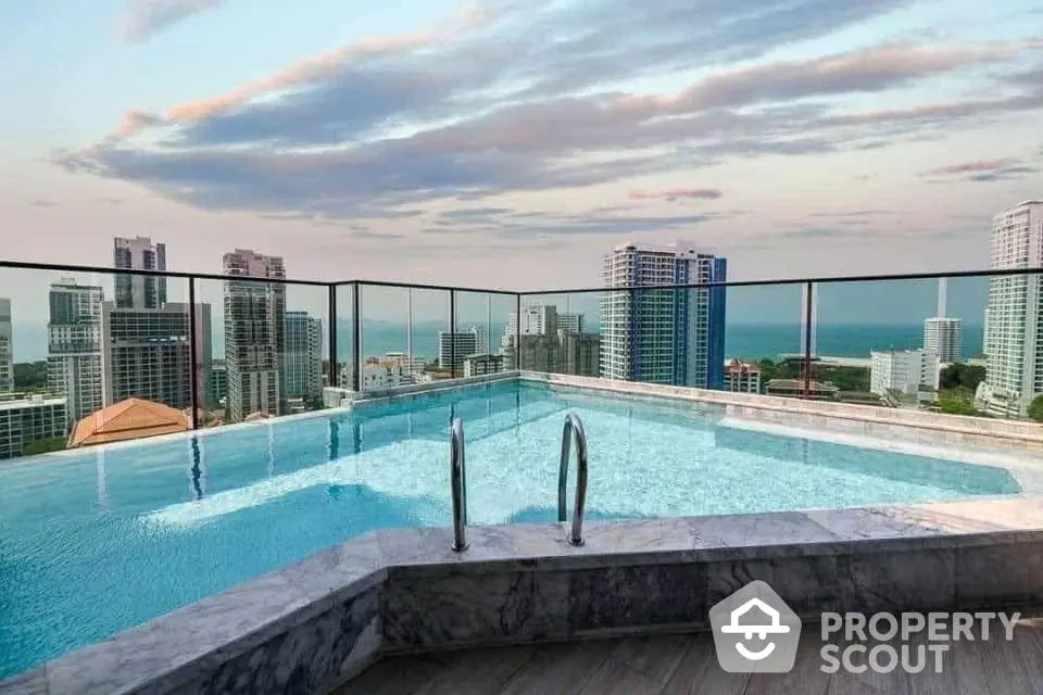 Stunning rooftop pool with panoramic city and ocean views in luxury high-rise building.