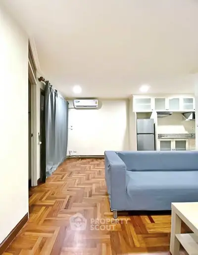 Spacious living room with modern kitchen and stylish parquet flooring