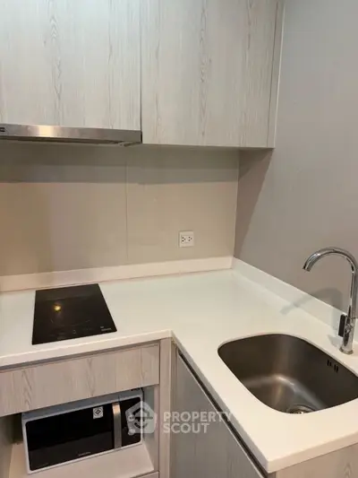 Modern compact kitchen with sleek cabinetry and built-in appliances
