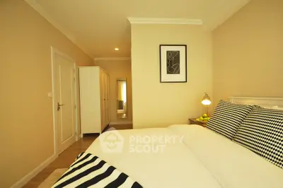 Spacious bedroom with modern decor and ample storage in a stylish apartment.
