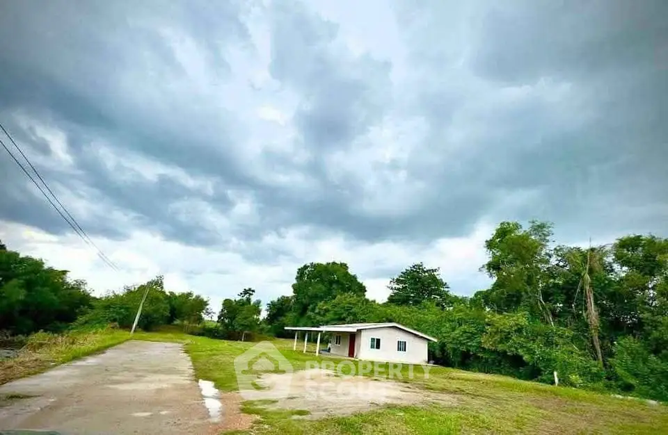 Charming countryside house with lush greenery and expansive sky view.