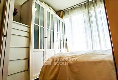 Bright bedroom with large windows and white furniture, perfect for cozy living.