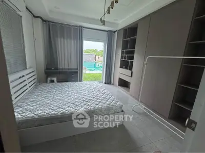 Spacious bedroom with pool view and modern furnishings