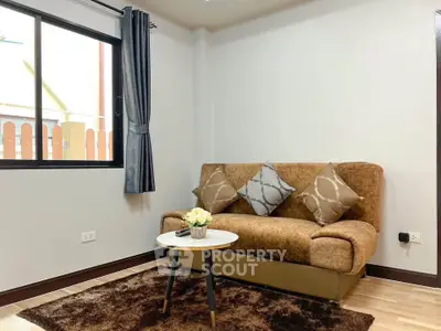 Cozy living room with plush brown sofa, stylish cushions, and elegant decor in a modern apartment.