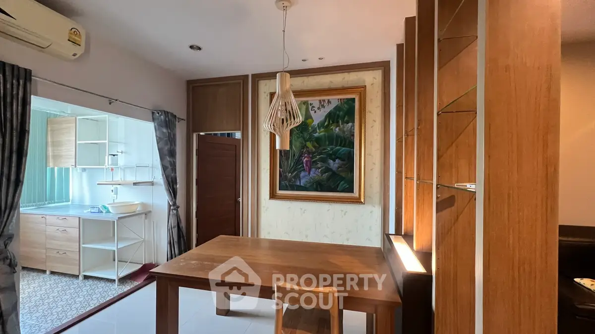 Charming dining area with wooden table and artistic decor in a cozy apartment setting.