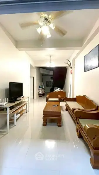 Spacious living room with elegant wooden furniture and ceiling fan