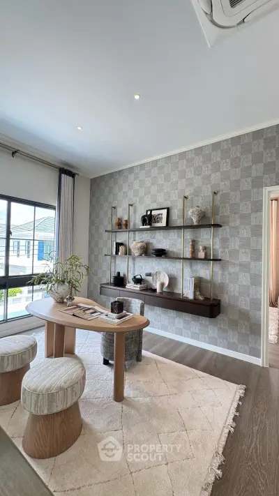 Stylish living room with modern decor, elegant shelving, and large windows offering natural light.