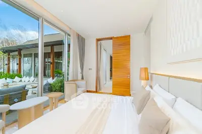 Luxurious bedroom with large windows and garden view, featuring elegant decor and natural light.