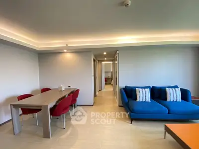 Spacious modern living room with stylish blue sofa and elegant dining area, perfect for entertaining.