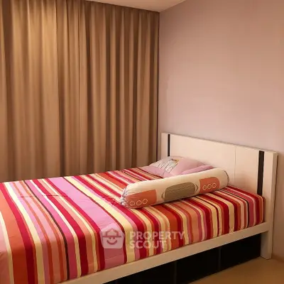 Cozy bedroom with striped bedding and elegant curtains