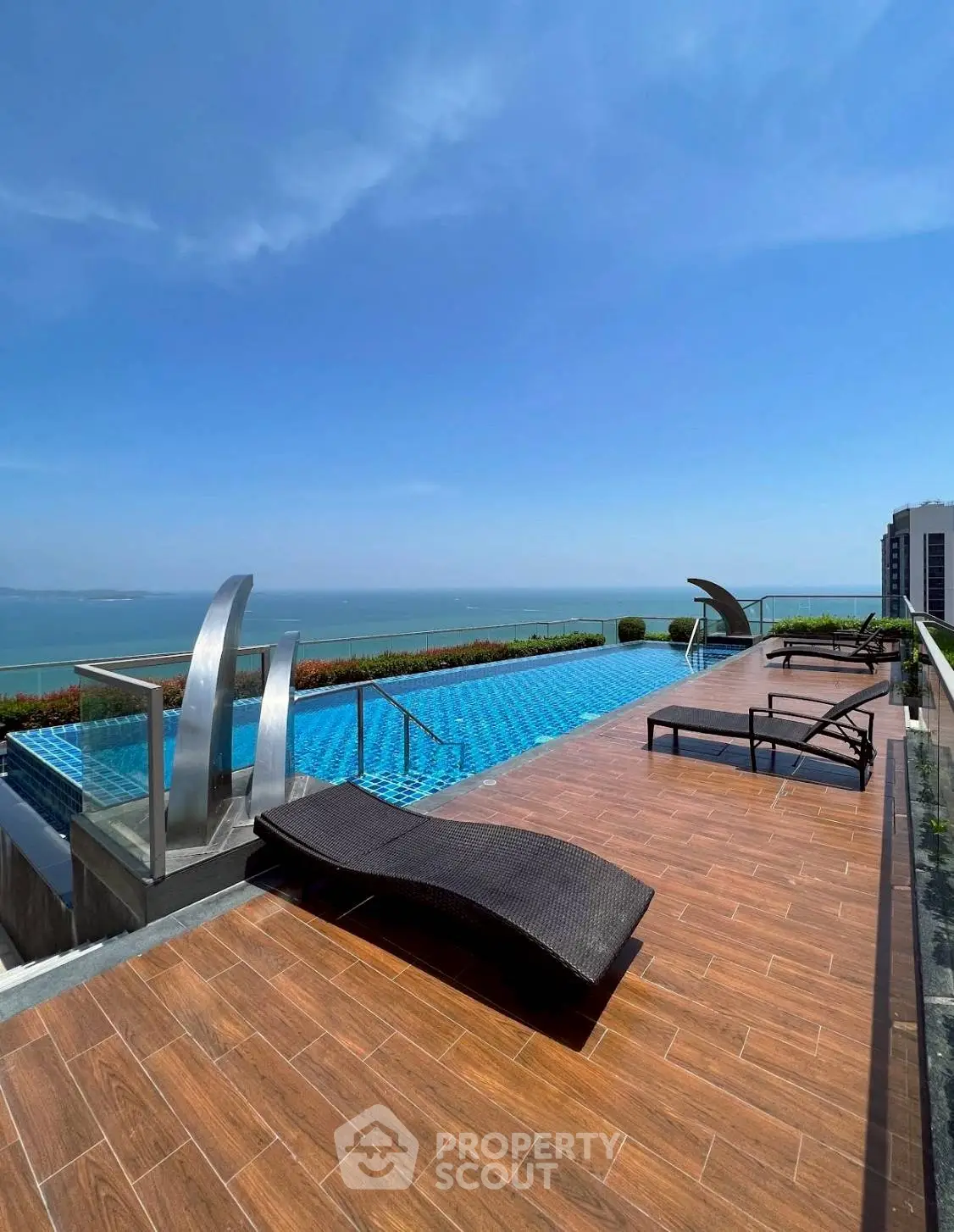 Luxurious rooftop pool with stunning ocean view and modern lounge chairs.
