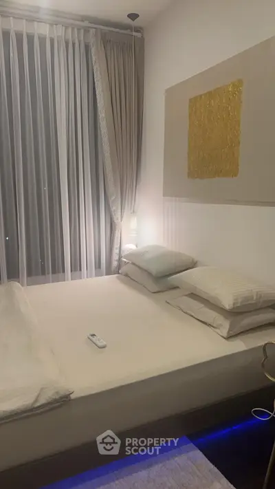 Modern bedroom with elegant decor and ambient lighting, featuring a cozy bed and floor-to-ceiling curtains.