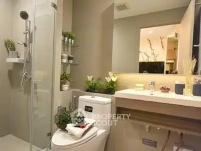 Modern bathroom with glass shower, sleek vanity, and elegant decor