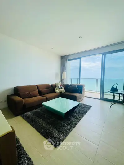 Spacious living room with ocean view and modern furnishings in a luxury apartment.