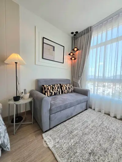 Cozy living room with stylish decor and large window offering natural light.