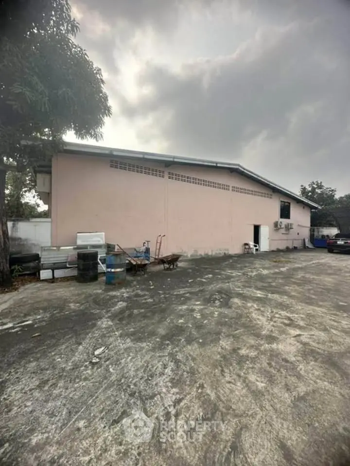 Spacious industrial warehouse exterior with ample parking space and secure surroundings.